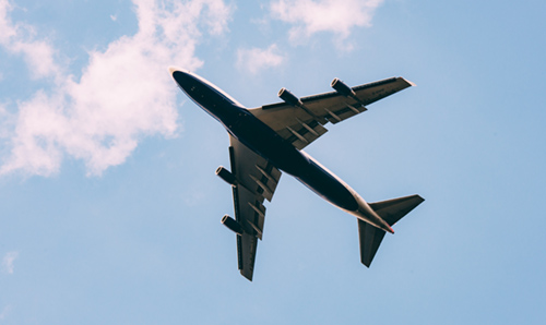 Looking up at the underside of an aeroplane in flight.